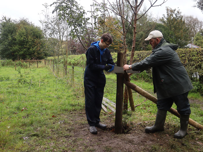 Alexander Hodge teaches a student hot to secure a fence post during a session at Myerscough College in 2023.