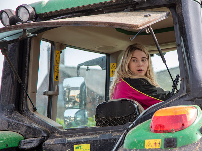 Young farmer reversing her tractor.