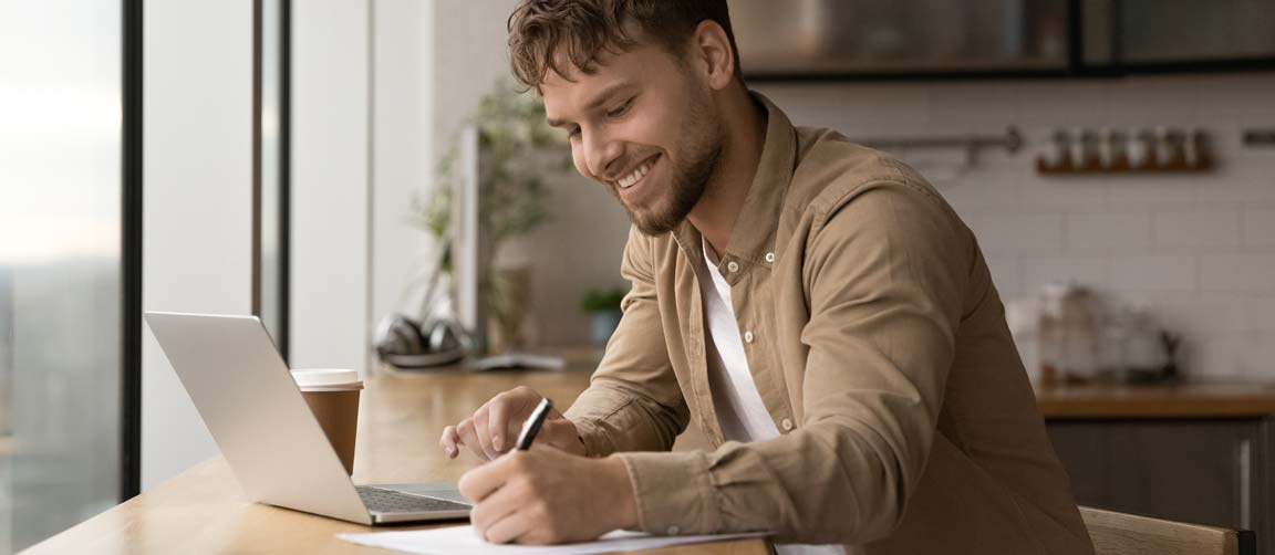 Young man researching training providers online.