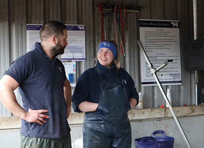 A man and woman talking inside a farm building