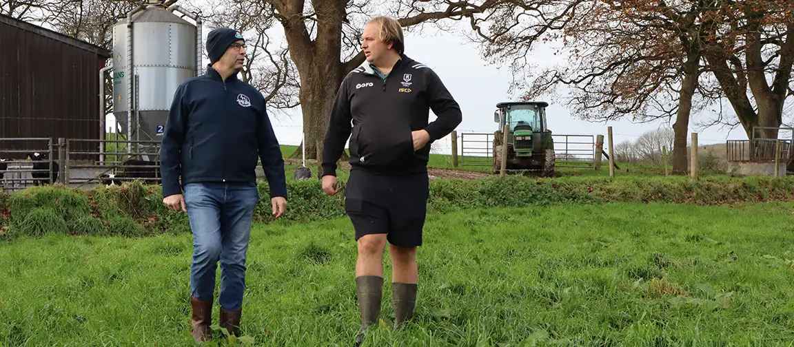 George (left) and Will Holmes walking through a grazing field on-farm in Dorset.