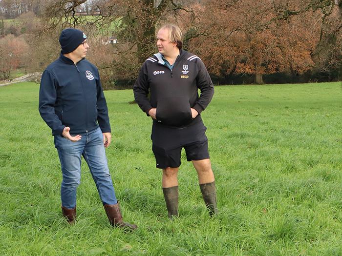 Will and George Holmes walking a grazing field on their farm in Dorset while discussing their succession plan.