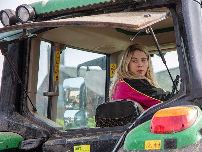 Young farmer reversing her tractor.